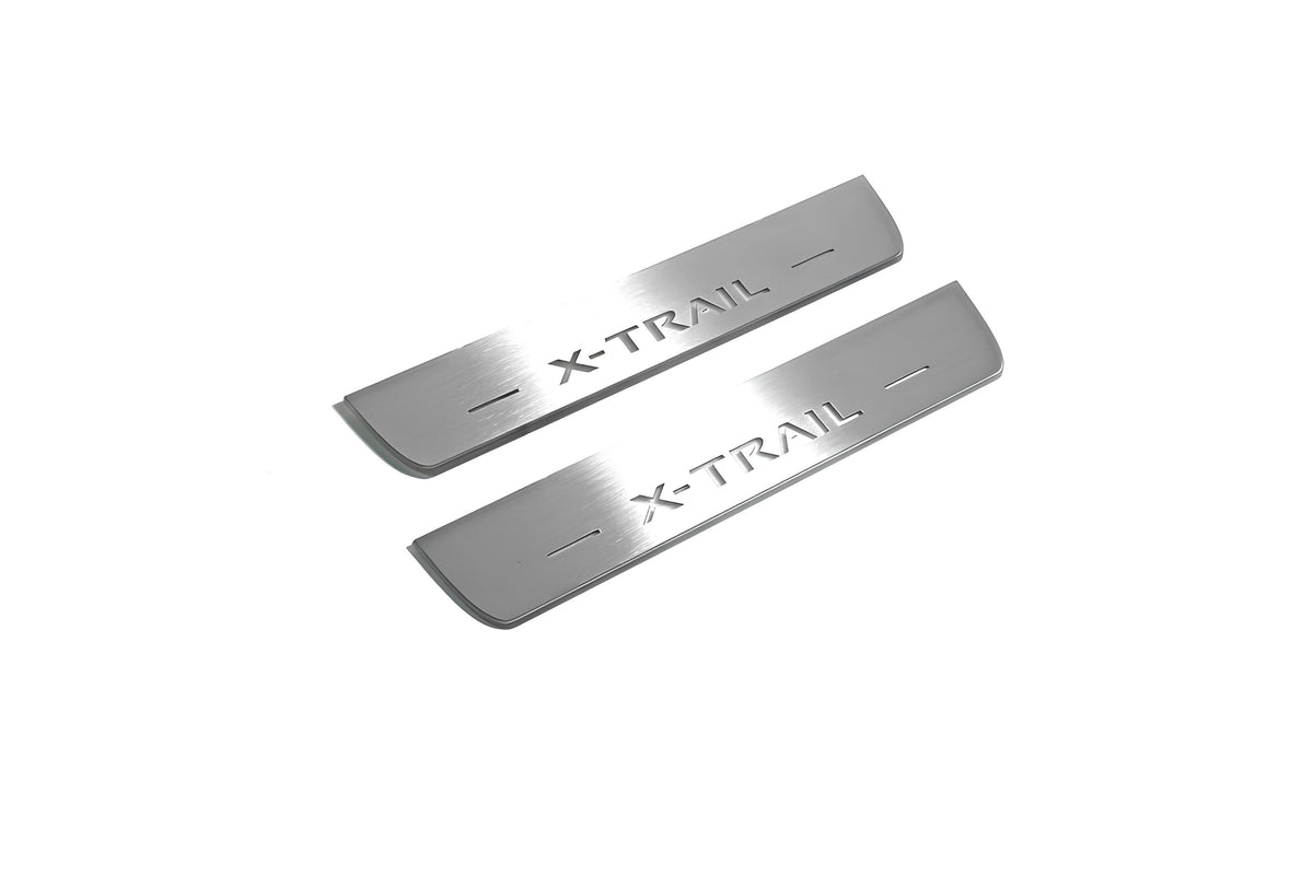 Two short silver-finished door sill plates with X-Trail lettering on a light background, angled view.