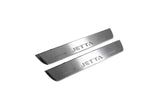 Two short silver-finished door sill plates with Jetta lettering on a light background, angled view.