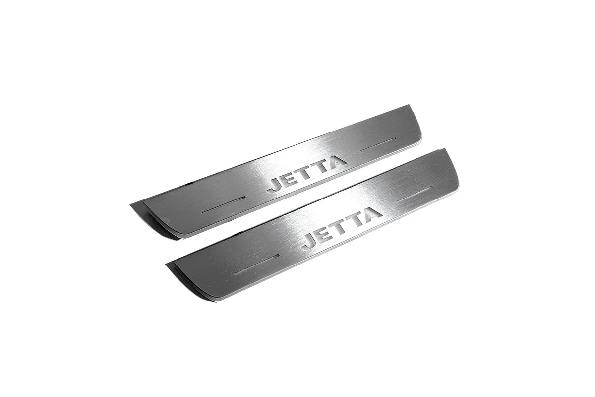 Two short silver-finished door sill plates with Jetta lettering on a light background, angled view.