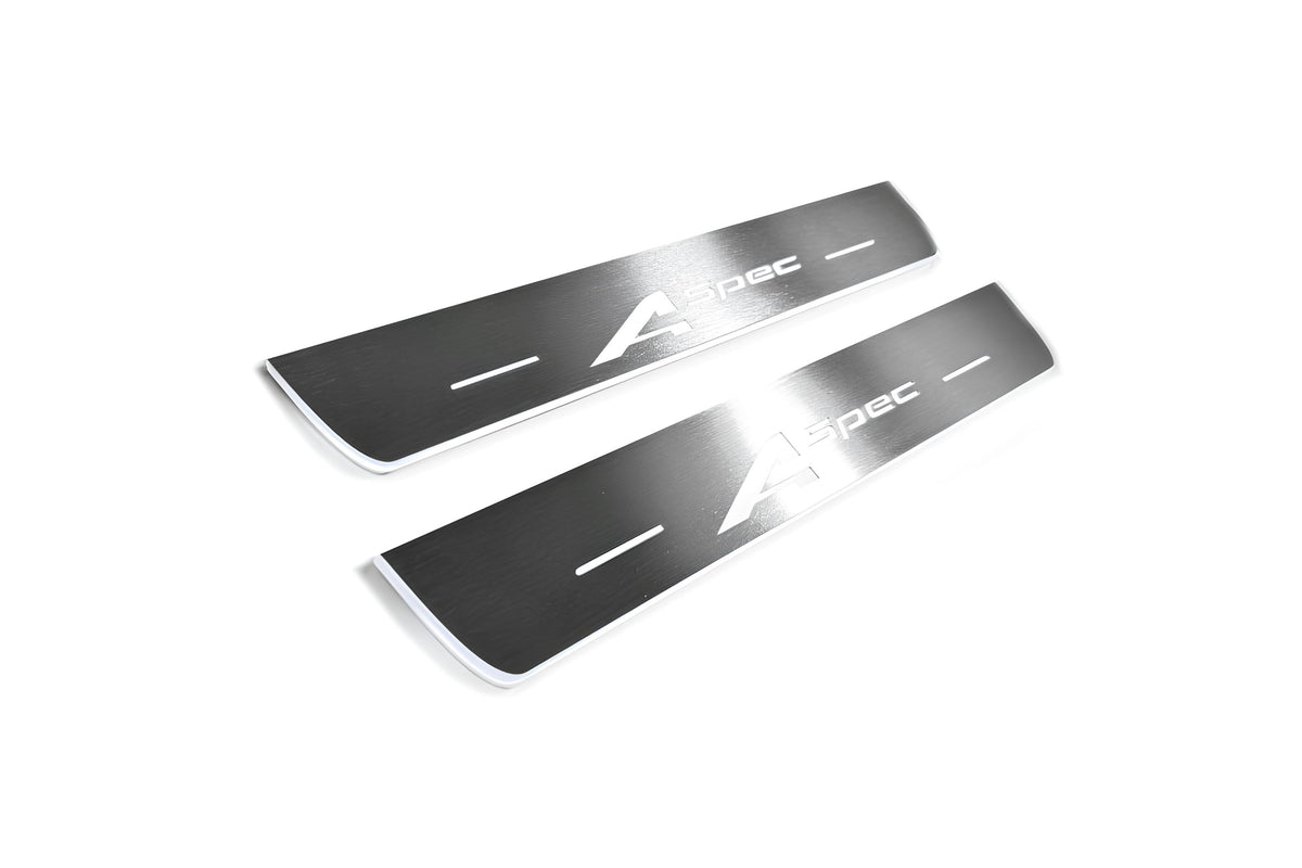 Two short silver-finished door sill plates with A-Spec lettering on a light background, angled view.