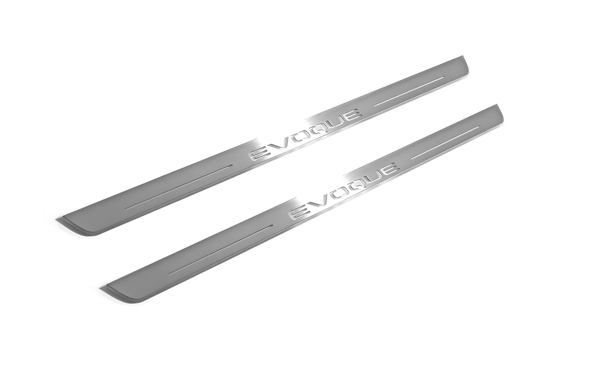 Two long silver-finished door sill plates with Evoque lettering on a light background, angled view.