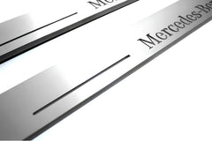 Close-up of Mercedes-Benz lettering and linear slots in silver-finished door sill plates.