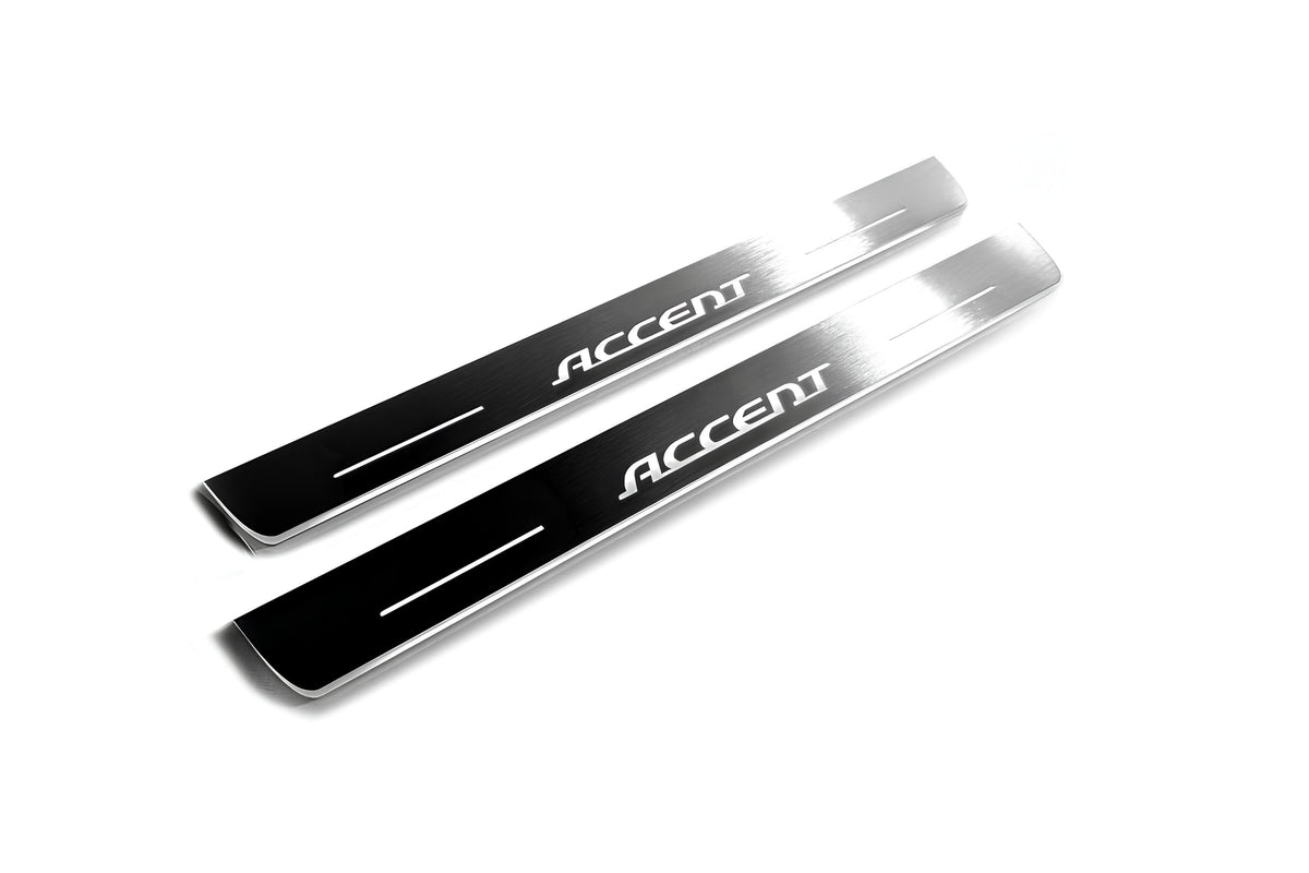 Two long silver-finished door sill plates with Accent lettering on a light background, angled view.