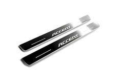 Two long silver-finished door sill plates with Accent lettering on a light background, angled view.