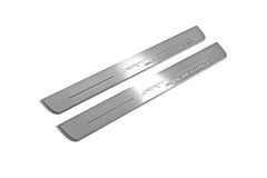 Two long silver-finished door sill plates with SRT Supercharged lettering on a light background, angled view.