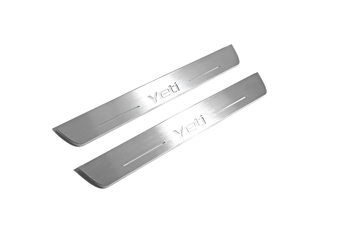 Two long silver-finished door sill plates with Yeti lettering on a light background, angled view.