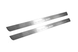 Two long silver-finished door sill plates with Impreza lettering on a light background, angled view.