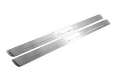 Two long silver-finished door sill plates with Carrera lettering on a light background, angled view.