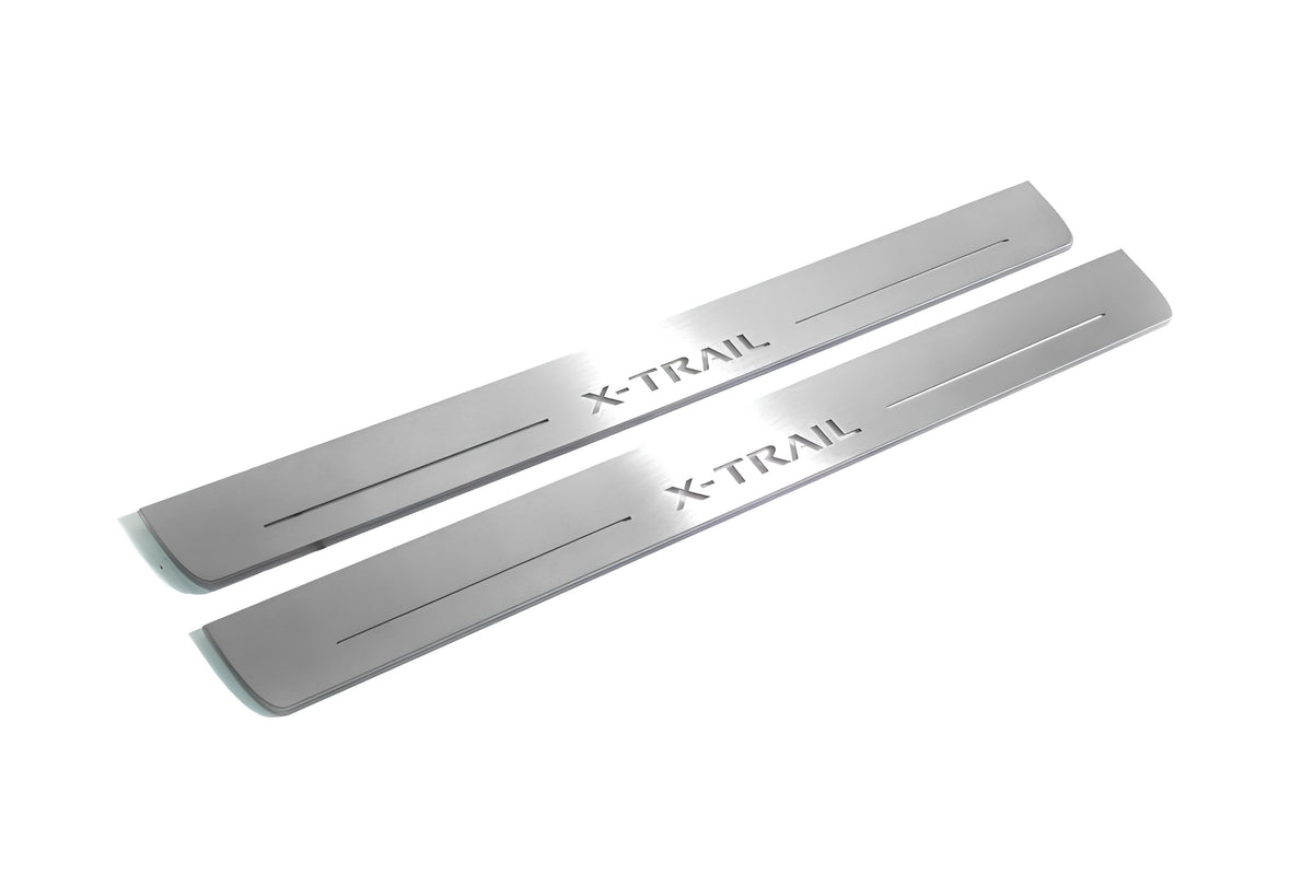 Two long silver-finished door sill plates with X-Trail lettering on a light background, angled view.