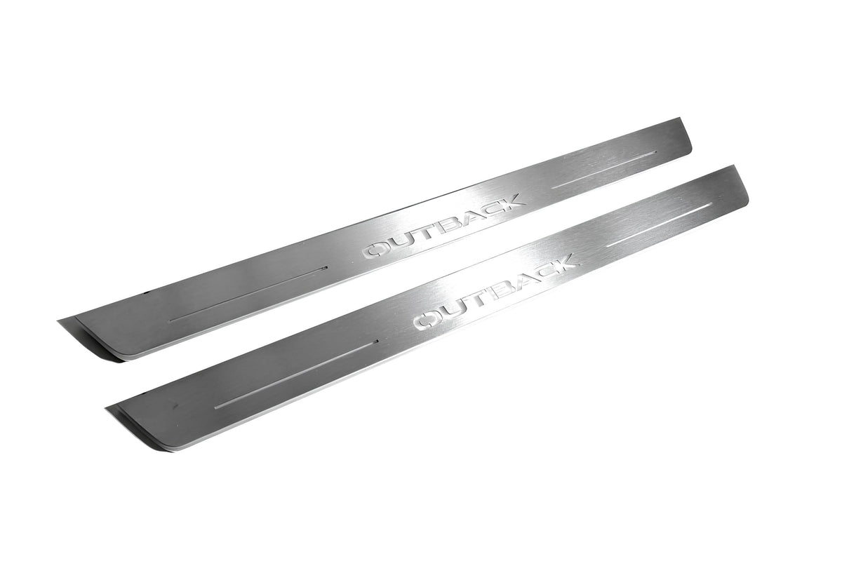 Two long silver-finished door sill plates with Outback lettering on a light background, angled view.