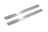 Two long silver-finished door sill plates with Camaro lettering on a light background, angled view.
