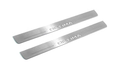 Two long silver-finished door sill plates with Optima lettering on a light background, angled view.