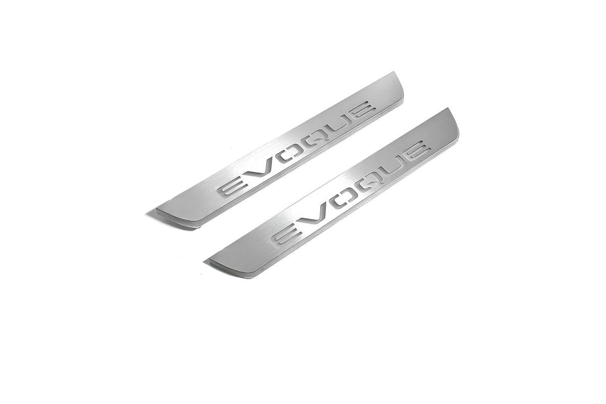 Two short silver-finished door sill plates with Evoque lettering on a light background, angled view.