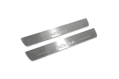 Two long silver-finished door sill plates with Acura lettering on a light background, angled view.