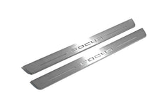 Two long silver-finished door sill plates with Focus lettering on a light background, angled view.