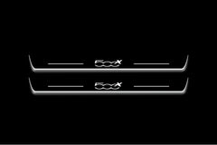Two long door sill plates with 500X lettering and edges illuminated in white, straight-on view on a dark background.