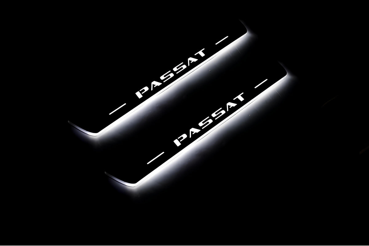 Two short door sill plates with Passat lettering and edges illuminated in white, angled view on a dark background.