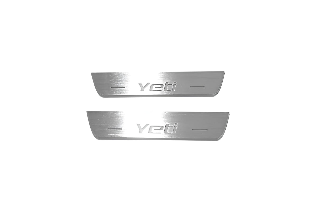 Two short silver-finished door sill plates with Yeti lettering on a light background, straight-on view.