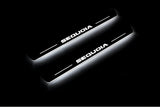 Two short door sill plates with Sequoia lettering and edges illuminated in white, angled view on a dark background.