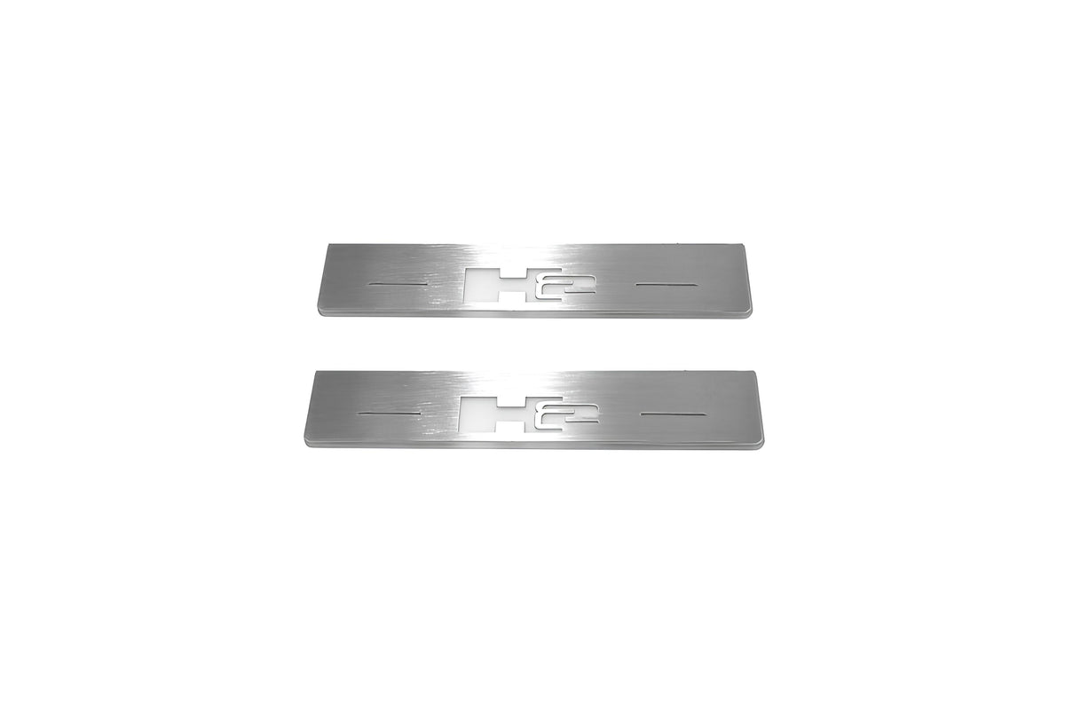 Two short silver-finished door sill plates with H2 lettering on a light background, straight-on view.