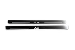 Two long reflective dark door sill plates with white A6 lettering and horizontal lines on a white background, straight-on view.