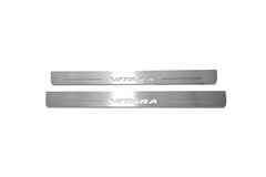 Two long silver-finished door sill plates with Vitara lettering on a light background, straight-on view.