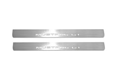 Two long silver-finished door sill plates with Mustang GT lettering on a light background, straight-on view.