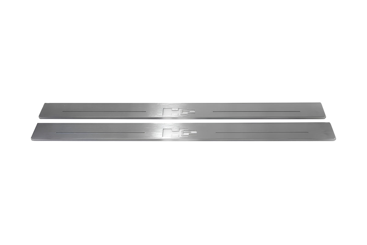 Two long silver-finished door sill plates with H2 lettering on a light background, straight-on view.