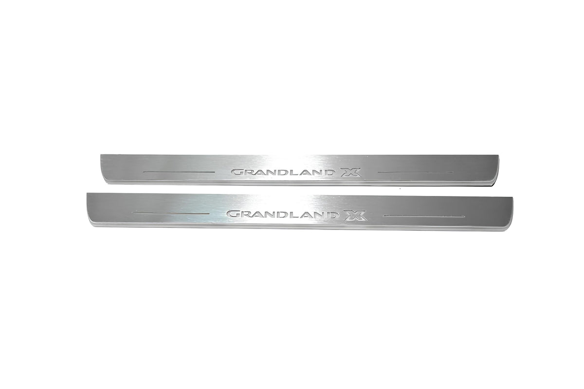 Two long silver-finished door sill plates with Grandland X lettering on a light background, straight-on view.