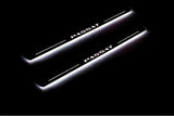 Two long door sill plates with Passat lettering and edges illuminated in white, angled view on a dark background.