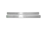 Two long silver-finished door sill plates with X-Trail lettering on a light background, straight-on view.