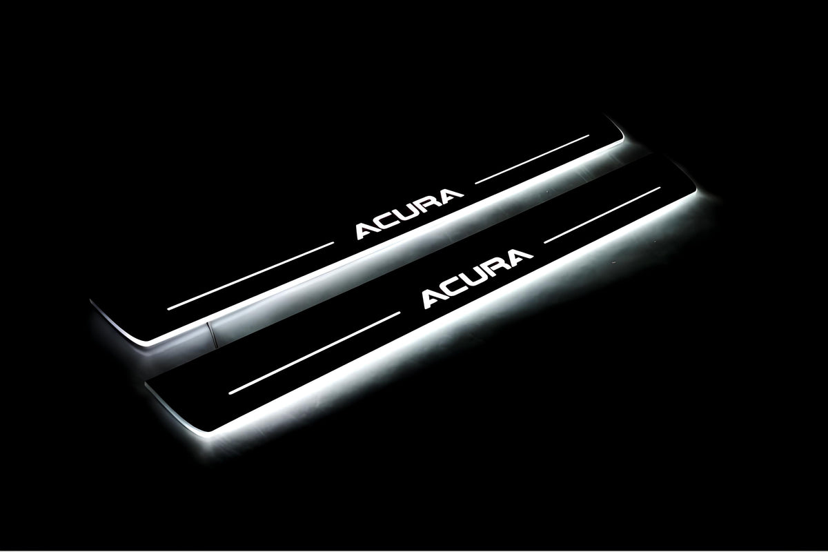 Two long door sill plates with Acura lettering and edges illuminated in white, angled view on a dark background.