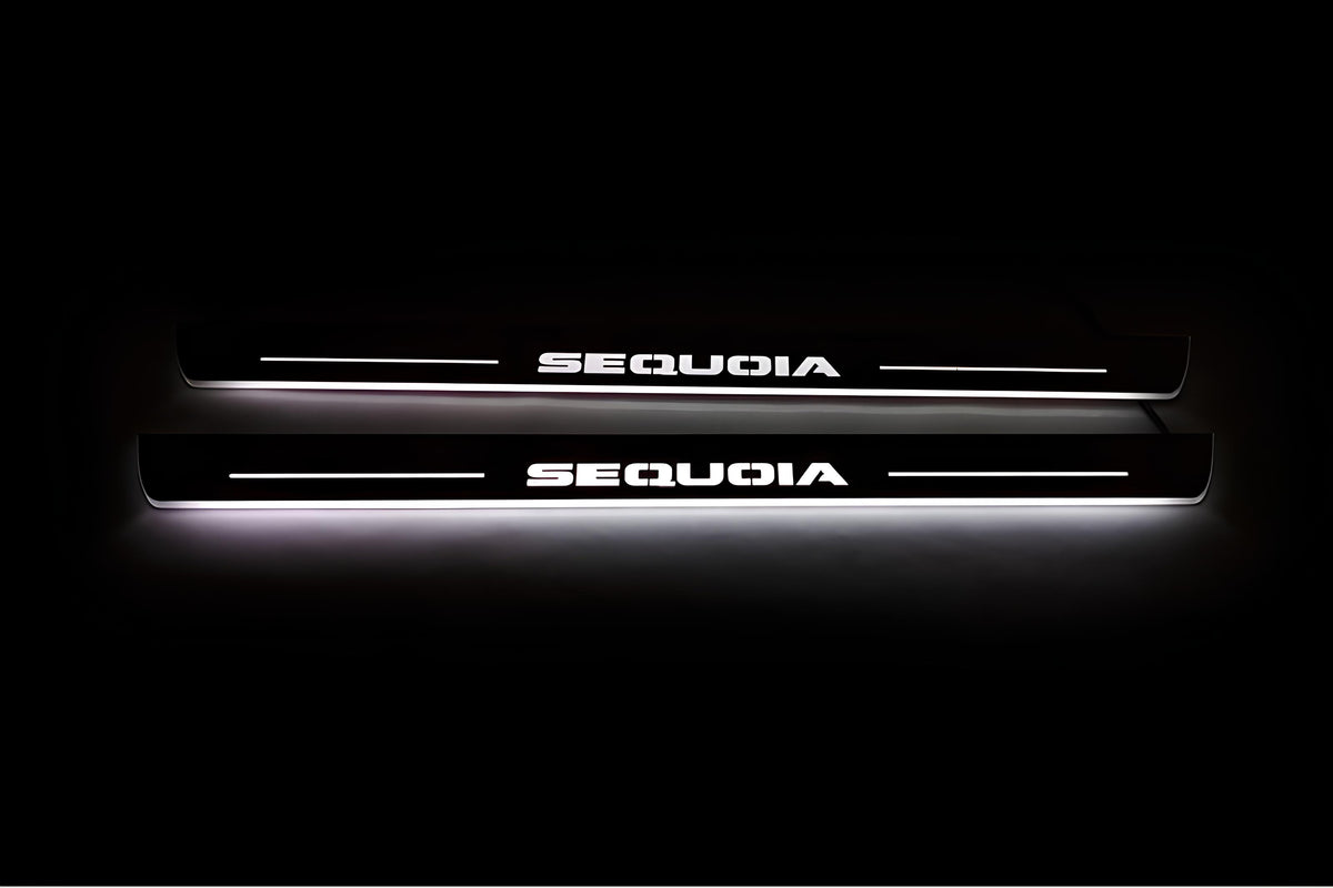 Two long door sill plates with Sequoia lettering and edges illuminated in white, straight-on view on a dark background.