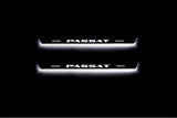 Two short door sill plates with Passat lettering and edges illuminated in white, straight-on view on a dark background.