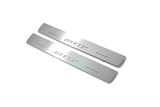 Two short silver-finished door sill plates with MDX lettering on a light background, angled view.