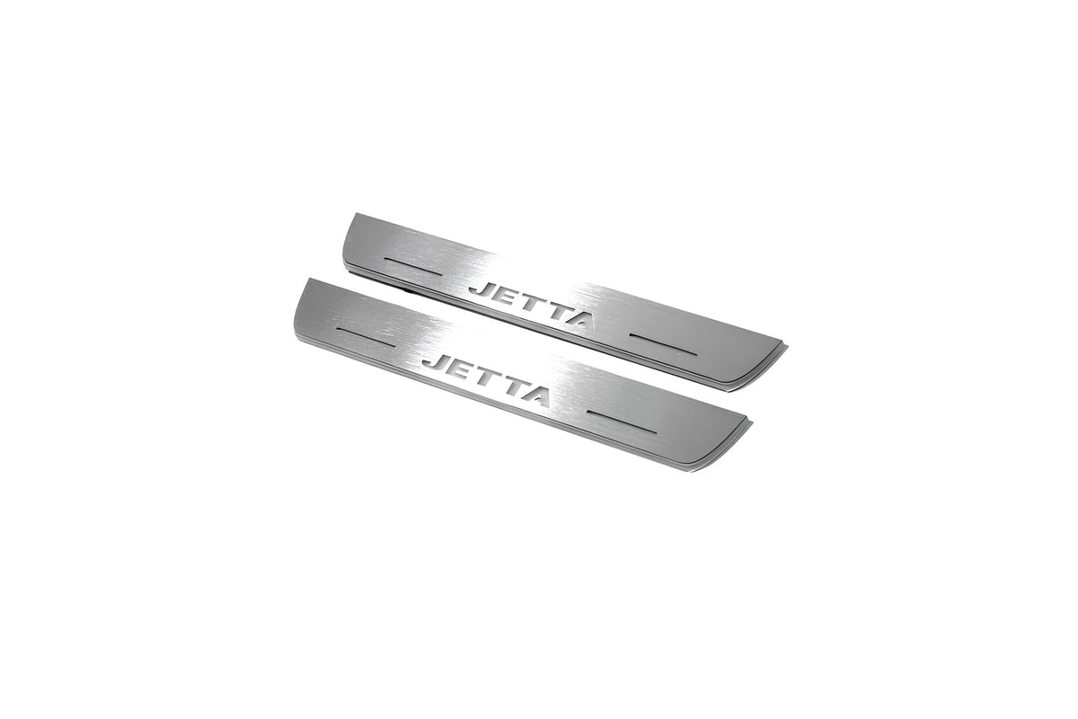 Two short silver-finished door sill plates with Jetta lettering on a light background, angled view.