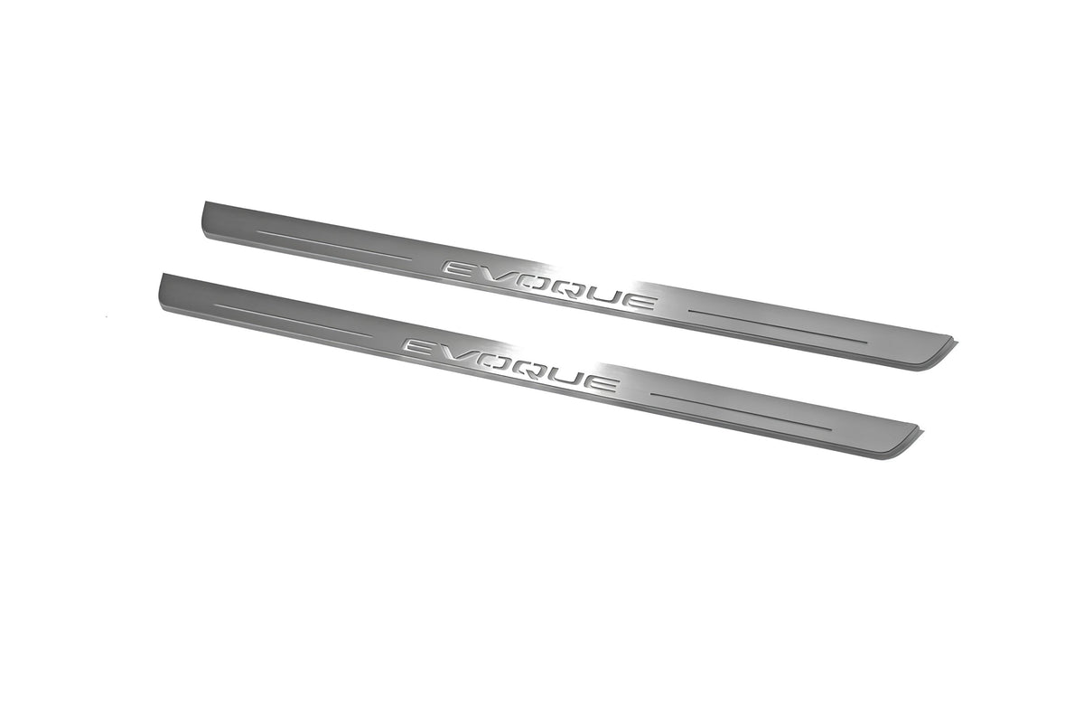 Two long silver-finished door sill plates with Evoque lettering on a light background, angled view.