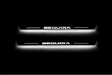Two short door sill plates with Sequoia lettering and edges illuminated in white, straight-on view on a dark background.