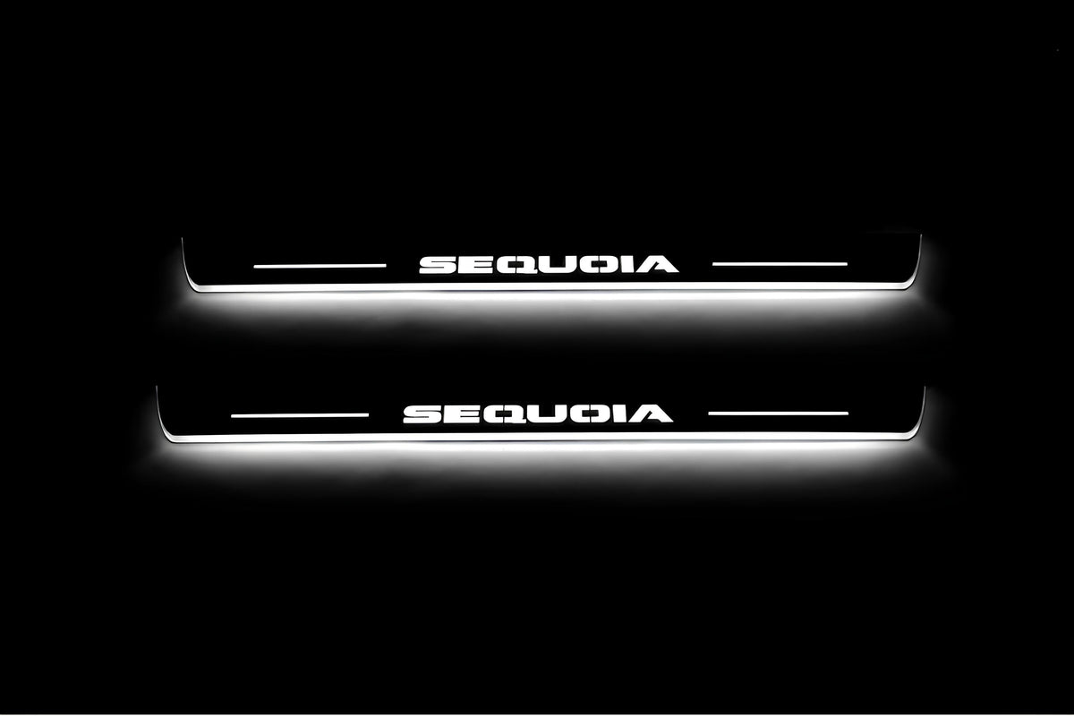 Two short door sill plates with Sequoia lettering and edges illuminated in white, straight-on view on a dark background.