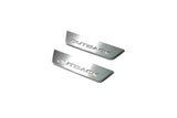 Two short silver-finished door sill plates with Outback lettering on a light background, angled view.