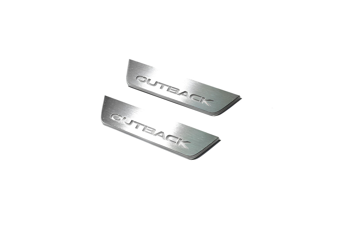 Two short silver-finished door sill plates with Outback lettering on a light background, angled view.