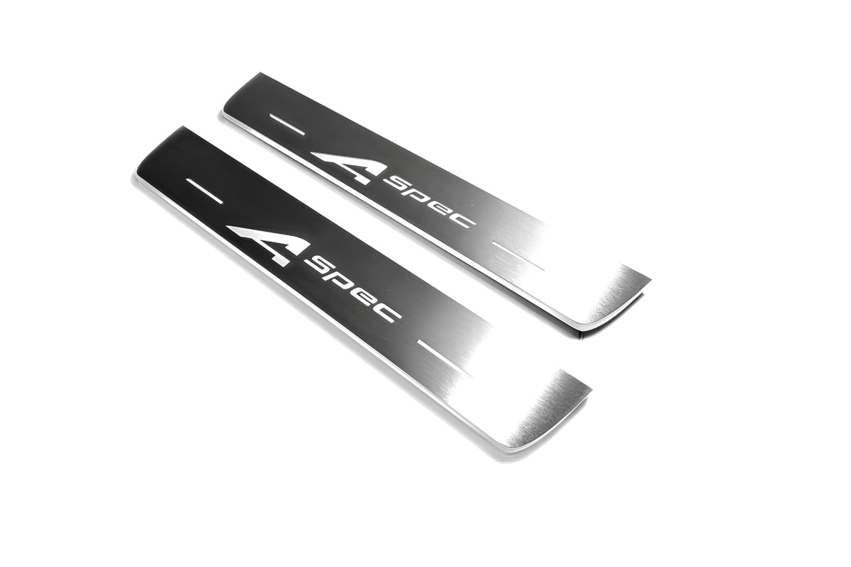 Two short silver-finished door sill plates with A-Spec lettering on a light background, angled view.