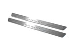 Two long silver-finished door sill plates with Outback lettering on a light background, angled view.