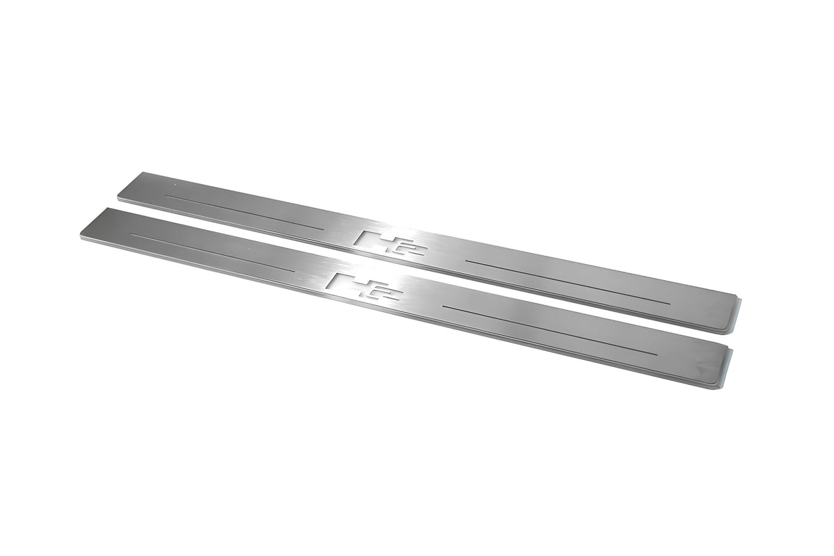 Two long silver-finished door sill plates with H2 lettering on a light background, angled view.