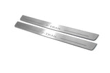 Two long silver-finished door sill plates with X-Trail lettering on a light background, angled view.