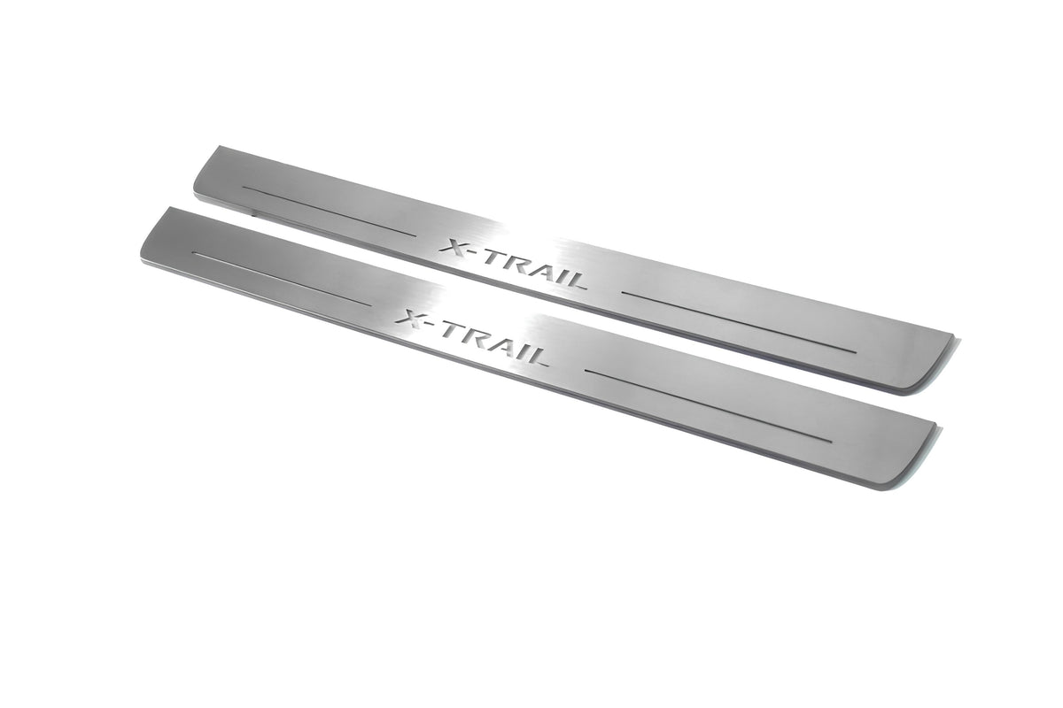 Two long silver-finished door sill plates with X-Trail lettering on a light background, angled view.