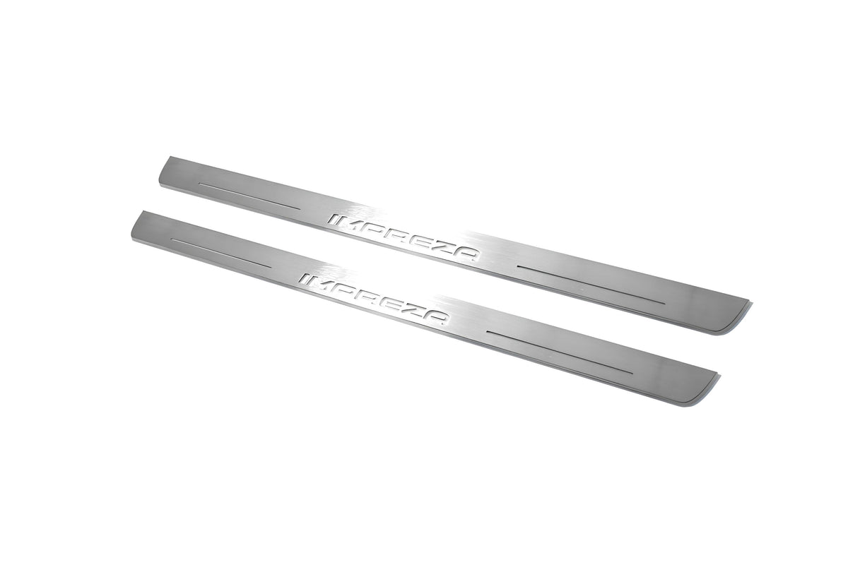 Two long silver-finished door sill plates with Impreza lettering on a light background, angled view.