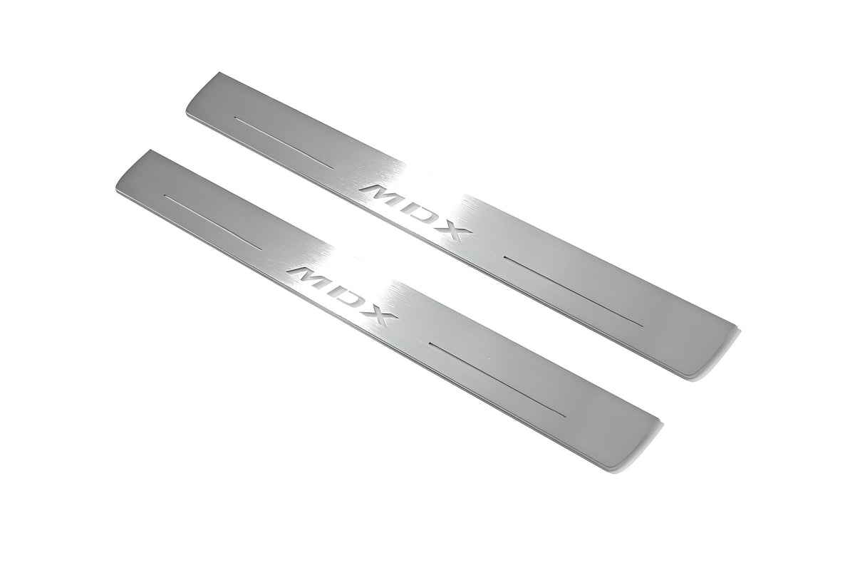 Two long silver-finished door sill plates with MDX lettering on a light background, angled view.