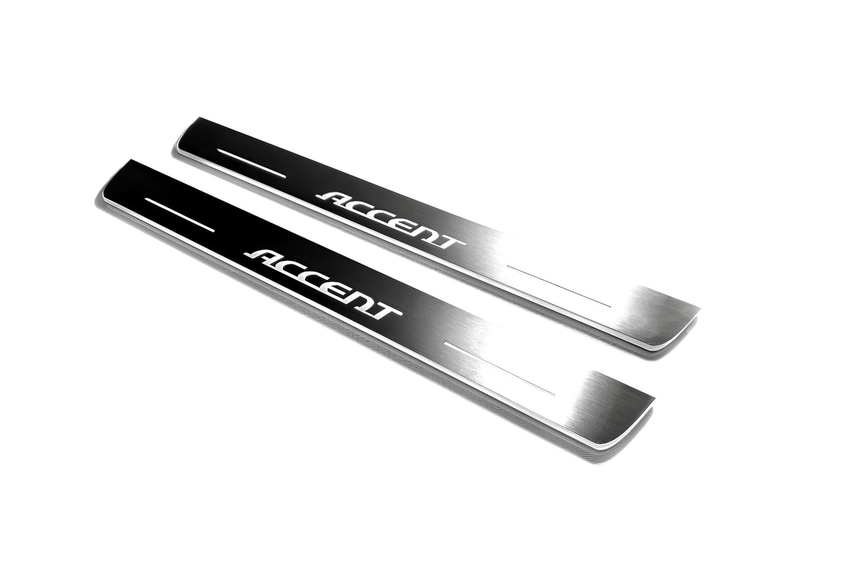 Two long silver-finished door sill plates with Accent lettering on a light background, angled view.