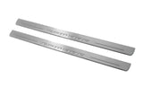 Two long silver-finished door sill plates with Camaro lettering on a light background, angled view.